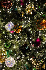 The Christmas tree's green trees, colorful, shiny, and ornaments are beautiful.