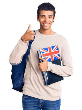 Young african amercian man wearing student backpack holding binder and uk flag smiling happy and positive, thumb up doing excellent and approval sign