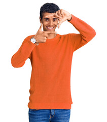 Young african amercian man wearing casual clothes smiling making frame with hands and fingers with happy face. creativity and photography concept.