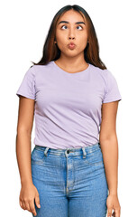 Young latin woman wearing casual clothes making fish face with lips, crazy and comical gesture. funny expression.