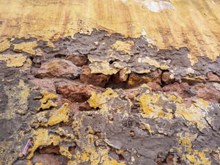 Weathered and damaged concrete wall made of cement and stones. Abstract grunge background.