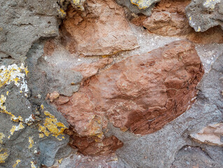 Weathered and damaged concrete wall made of cement and stones. Abstract grunge background.