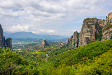 Fototapeta na wymiar Meteora rock towers Greece. Stunning landscape View at mountains and green forest against epic blue sky with clouds. UNESCO heritage list object.