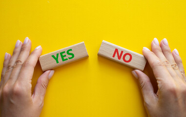Yes or No symbol. Concept word Yes or No on wooden blocks. Businessman hand. Beautiful yellow...