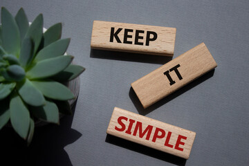 Keep it Simple symbol. Concept words Keep it Simple on wooden blocks. Beautiful grey background...