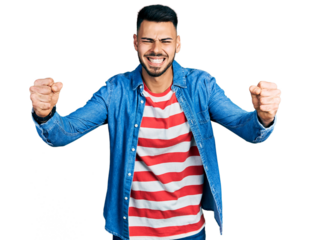 Young hispanic man with beard wearing casual denim jacket angry and mad raising fists frustrated and furious while shouting with anger. rage and aggressive concept.