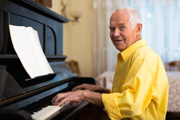 Old man playing piano at home