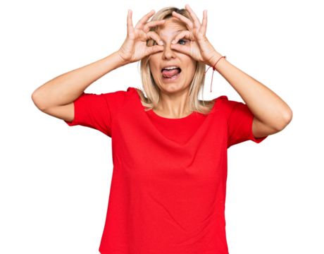 Middle age caucasian woman wearing casual clothes doing ok gesture like binoculars sticking tongue out, eyes looking through fingers. crazy expression.