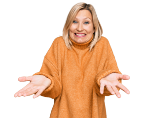 Middle age caucasian woman wearing casual winter sweater smiling cheerful with open arms as friendly welcome, positive and confident greetings