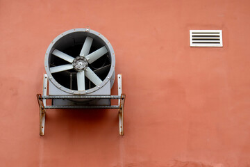 Propeller of the ventilation system on the wall of the building. View of installation of ventilation system engineering equipment on the wall of a building. The grille and propeller of the ventilation
