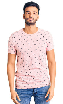 Young handsome hispanic man wearing casual clothes with serious expression on face. simple and natural looking at the camera.