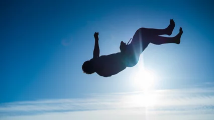 Foto op Plexiglas silhouette of a guy doing backflip in sunset © iago