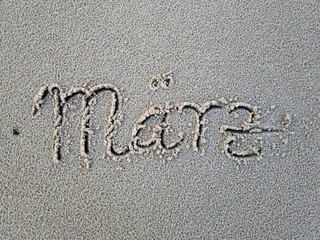 März als Wort im Strandsand