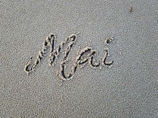 Mai als Wort im Strandsand