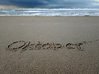 Oktober als Wort im Strandsand