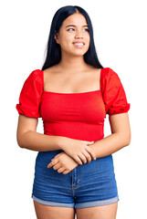 Fototapeta premium Young beautiful asian girl wearing casual clothes looking away to side with smile on face, natural expression. laughing confident.