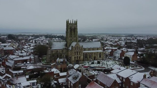 Drone shot. Snow winter scene. Church of England. Parish church in English countryside. Christian church worship UK. 