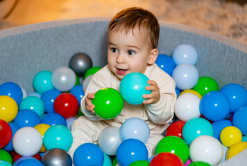 Fototapeta na wymiar A Playful Adventure in a Colorful Ball Pit Filled with Joy and Laughter. A baby sitting in a ball pit with lots of balls