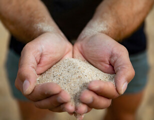 Cupped hands holding sand