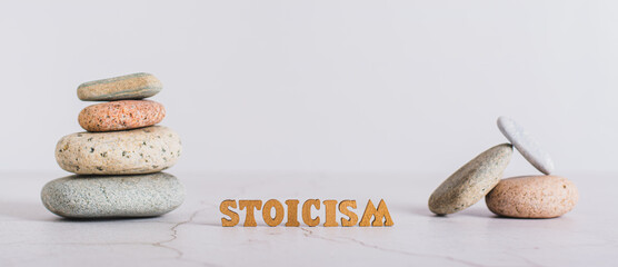 Concept stoicism word made from letters and pyramid of stones on gray background web banner