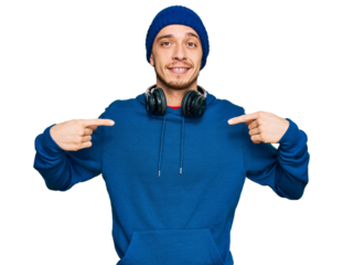 Hispanic young man wearing sweatshirt and wool hat looking confident with smile on face, pointing oneself with fingers proud and happy.