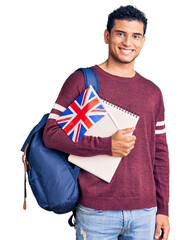 Hispanic handsome young man exchange student holding uk flag looking positive and happy standing...