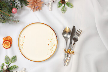 Christmas table setting, holiday menu layout, New Year's cutlery with napkin on a plate on a marble...