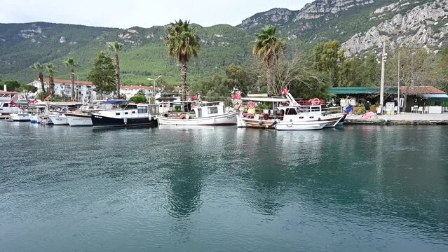 Akyaka is where water meets the sea. Clear water flowing under the bridge, boats lined up on the edge. Reeds and bird sanctuary on both sides of the water.  Azmak, Akyaka 