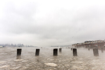 Hudson river in Winter with Misty New Your Cityscape in Background.