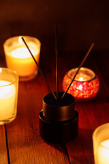 Black Reed Diffuser and Burning Candles on Wooden Table, Aromatherapy and Calming Concept