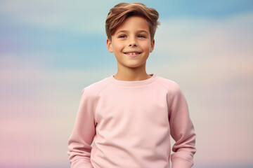 A young boy wearing a pink sweater smiles for the camera