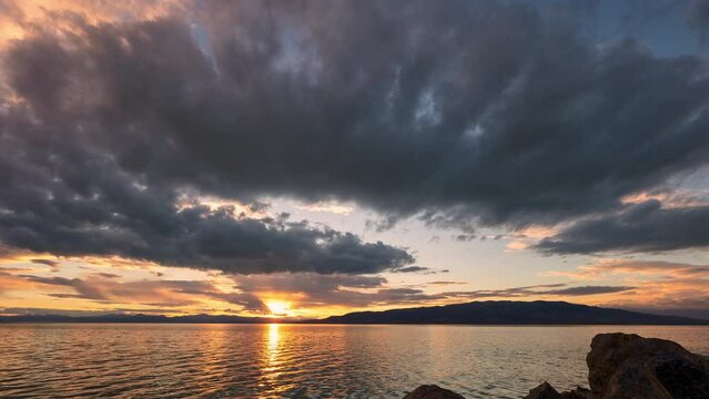 Timelapse of the sun setting over Utah Lake as clouds move through the sky.