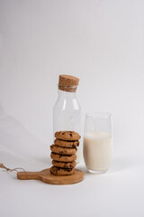 A bottle of fresh milk with chockolade chip cookies on the white background . Healthy food for breakfast or snack