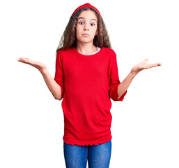 Cute hispanic child girl wearing casual clothes clueless and confused expression with arms and...