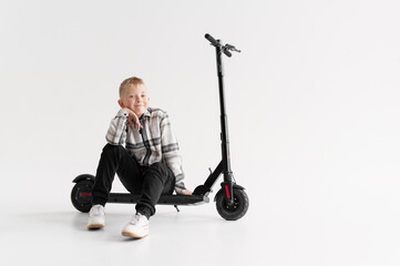 a boy near an electric scooter on a white background