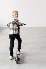 a boy near an electric scooter on a white background. Rear view.