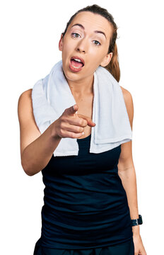Young caucasian woman wearing sportswear and towel pointing displeased and frustrated to the camera, angry and furious with you