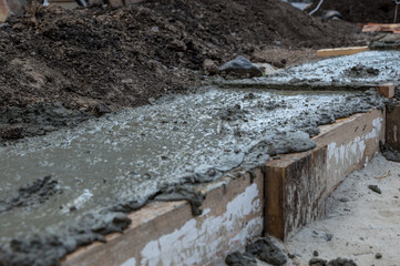 Fresh concrete poured into wooden formwork.