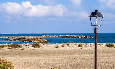 A old lantern on an empty beach of the Mediterranean coast in Saintes Maries de la Mer, Camargue, France