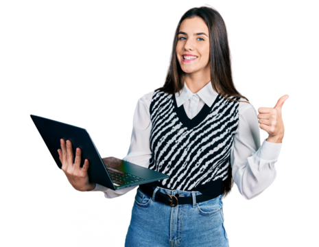 Young brunette teenager working using computer laptop smiling happy and positive, thumb up doing excellent and approval sign