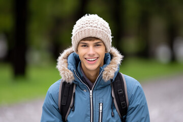 A young man wearing a knitted hat and a blue jacket