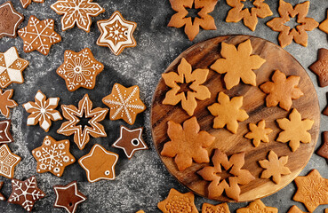 Various christmas gingerbread cookies on dark table with flour