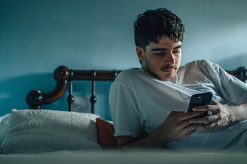 young man at home with mobile phone or smartphone