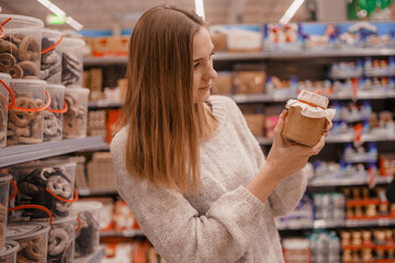 Stack of Chocolate Santa Clauses. Christmas time. A young woman chooses a gift set for Christmas to...