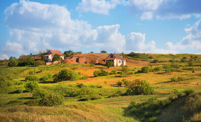 Pastoral landscape with old houses in a field