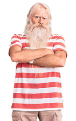 Old senior man with grey hair and long beard wearing striped tshirt skeptic and nervous, disapproving expression on face with crossed arms. negative person.