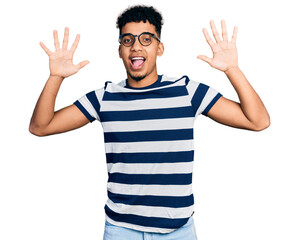 Young african american man wearing casual clothes and glasses showing and pointing up with fingers number ten while smiling confident and happy.