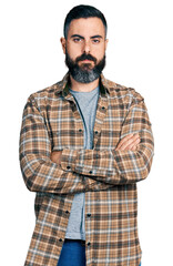 Hispanic man with beard with arms crossed gesture relaxed with serious expression on face. simple and natural looking at the camera.