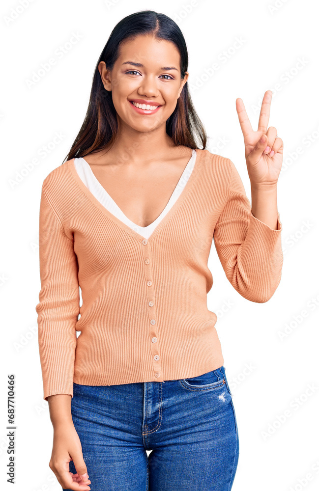 Sticker Young beautiful latin girl wearing casual clothes smiling with happy face winking at the camera doing victory sign. number two.