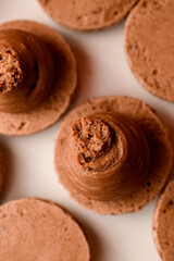 Close-up photo from above of a macaroon half with brown cream